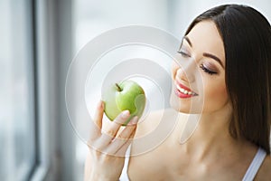 Woman Eating Apple. Beautiful Girl With White Teeth Biting Apple