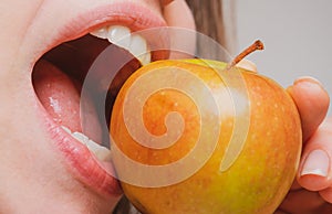 Woman eating apple healthy diet and healhy teeth. Biting an apple. Mouth close up.