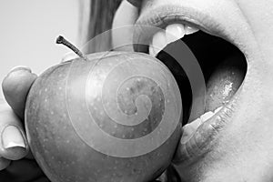 Woman eating apple healthy diet and healhy teeth. Biting an apple. Mouth close up.