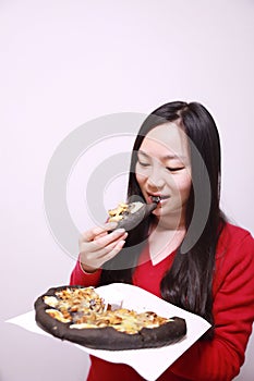 Woman eating black pizza