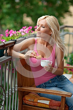 Woman eating breakfast on balcony