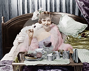 Woman eating breakfast in bed photo