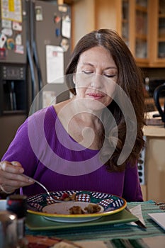 Woman eating breakfast at home