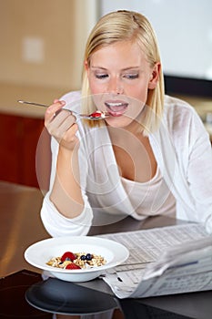 Woman, eating breakfast and reading newspaper to relax, peace and newsletter at home. Female person, breaking news and