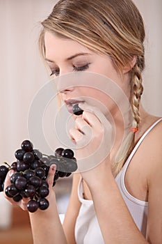 Woman eating bunch of grapes