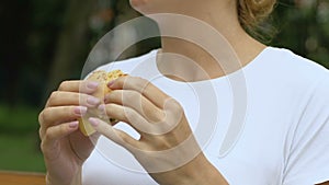 Woman eating burger, feels sudden pain in upper abdomen, gastritis, junk food