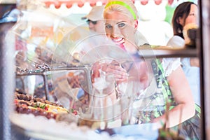 Woman eating candy apple at Oktoberfest or Dult