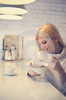 Woman eating cereals for breakfast.