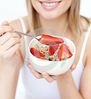 Woman eating cereals with strawberries