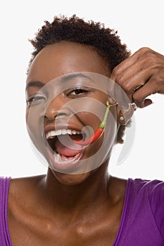 Woman eating chili pepper