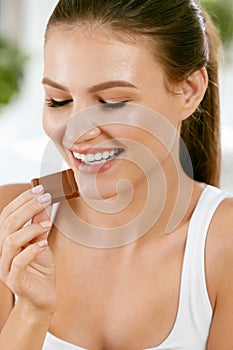 Woman Eating Chocolate. Beautiful Girl With Sweets.