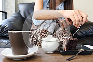 Woman eating chocolate cake and coffee