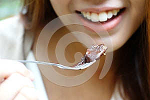 Woman eating chocolate cake with fork