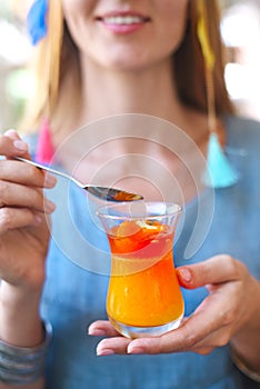 Woman eating citrus cumquat jelly dessert photo