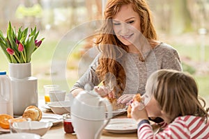 Woman eating croissants with son