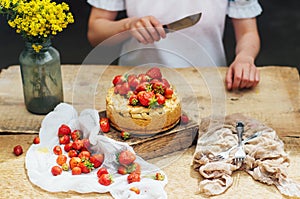 Woman eating a delicious home-made cake with aisheny and stuffed strawberries for dessert. Summer Styled dinner table. Coffee to