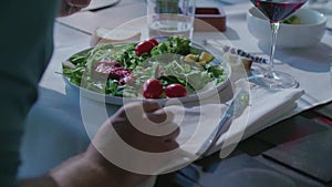 Woman eating detail on dish.Four caucasian friends people mediterranean italian salad,meat steak and bread lunch or