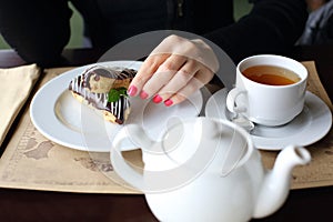 Woman eating eclairs with chocolate frosting for