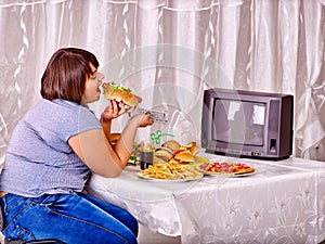 Woman eating fast food and watching TV