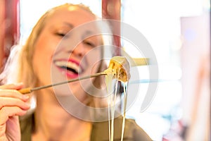 Woman eating fondue cheese