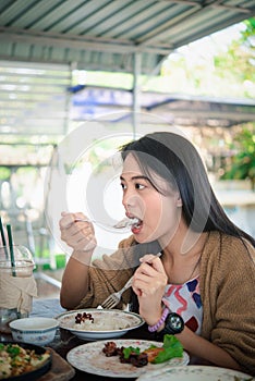 Woman eating food on dining table in restaurant