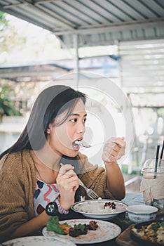 Woman eating food on dining table in restaurant