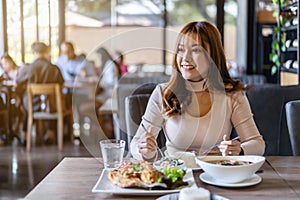 Woman eating with food in restaurant