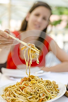 Woman eating fried noodles