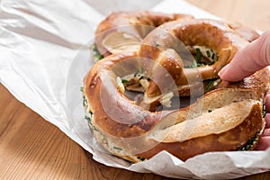 Woman eating German Brezel pretzel with chives and butter