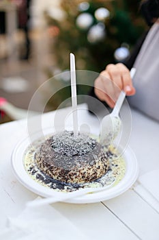 Woman eating germknodel at christmas food stand.