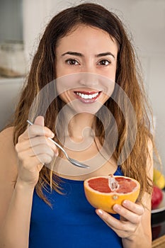 Woman eating grapefruit with a spoon