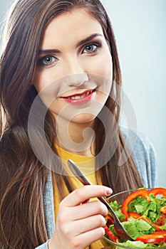 Woman eating green salad . Female model close up face studio is