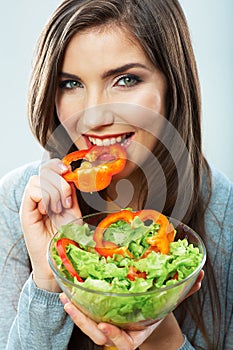 Woman eating green salad . Female model close up face studio is