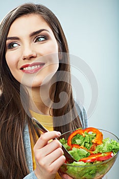 Woman eating green salad . Female model close up face studio is