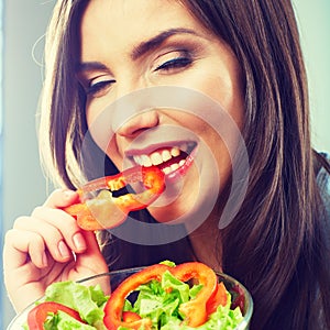 Woman eating green salad . Female model close up face studio iso