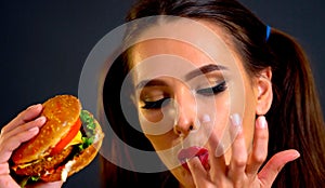 Woman eating hamburger. Girl wants to eat fast food.