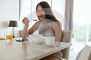 Woman eating healthy breakfast at home in morning at table