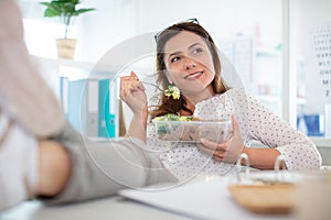 woman eating healthy business lunch in modern office