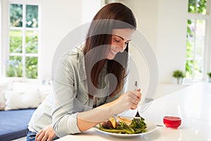 Woman Eating Healthy Meal In Kitchen