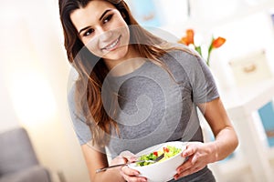 Woman eating healthy salad at home