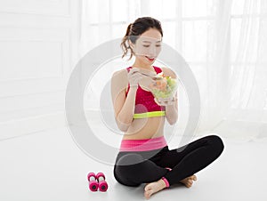 Woman eating healthy salad after workout