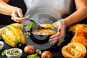 Woman eating homemade pumpkin cream soup. Vegetarian healthy diet food concept.