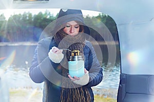 Woman is eating a hot dish from a thermos