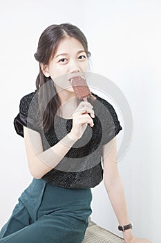 Woman eating ice cream in studio light