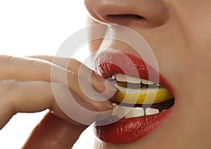 Woman eating juicy lemon, close-up lips on a white background.