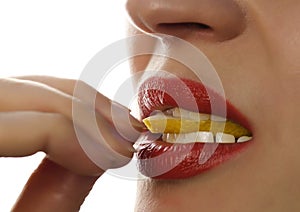 Woman eating juicy lemon, close-up lips on a white background.