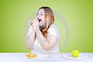 Woman eating junk food and refuse healthy food