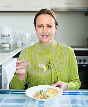 Woman eating at kitchen