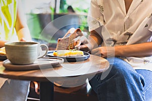 Woman eating lemom pie tart cake with coffee on table.