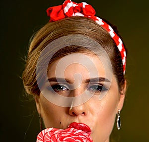 Woman eating lollipops. Girl in pin-up style hold striped candy.